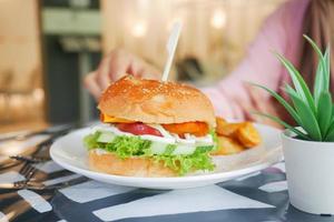 Burger and french fries on a cafe table photo