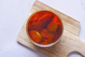 Homemade Mango Pickle in a glass jar on table , photo