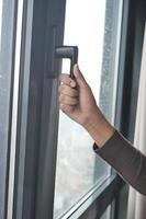 women hand holding door or window handle photo