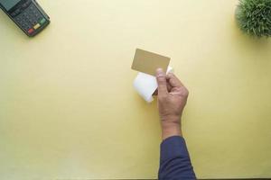 top view of person hand holding credit card and a sales receipt photo