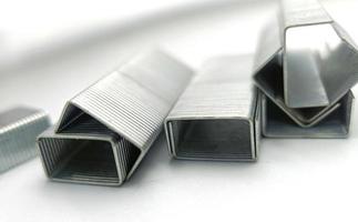 macro shot, stack of metal staples for stapler on a white background photo