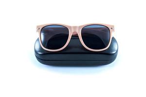 pink sunglasses in black case box on white background photo