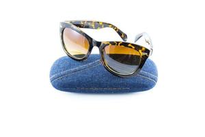 black sunglasses in jean case on white background photo