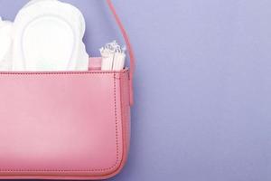 tampones, panty liners higiénicos, toallas sanitarias femeninas en una bolsa cosmética rosa para mujer foto