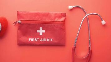 first aid kit ,stethoscope and heart shape on red video