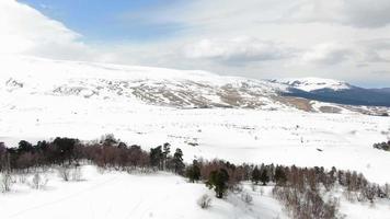lindo inverno montanha panorama em uma nublado dia aéreo tomada. esqui recorrer topo visualizar. video