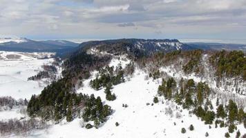 lindo inverno montanha panorama em uma nublado dia aéreo tomada. esqui recorrer topo visualizar. video