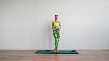 Athletic Woman Trainer Leads an Online Stretching Workout on a White Background. Online Learning Concept and E-learning. video