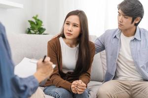 psicología, depresión asiático joven pareja, paciente consultante problema mental salud con psicólogo, psiquiatra a clínica juntos, marido alentador por participación mano de esposa, terapia salud cuidado foto