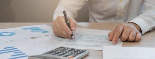 Close up hand of stress asian young employee business man, male calculate tax income and expenses, bills, credit card for payment or payday on table at home office. Financial, finance people concept. photo