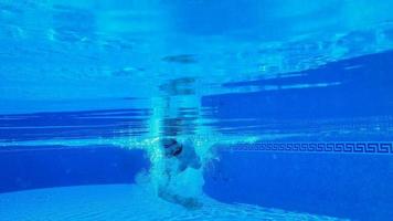 Underwater shooting as a man swims under the water video