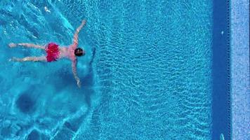 Aerial view of man in red shorts swims in the pool video