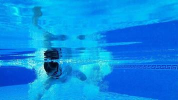 Underwater shooting as a man swims under the water video