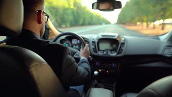 uomo guida un' auto su il strada nel soleggiato tempo metereologico e perdente controllo durante il giro. Visualizza a partire dal dietro a il autista video