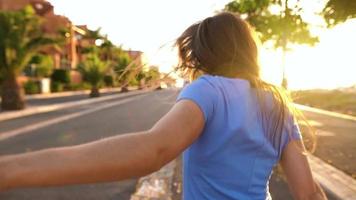 seguir yo - contento joven mujer tracción tipo mano - mano en mano corriendo en un brillante soleado día. lento movimiento video