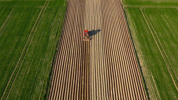 Aerial view of tractor performs seeding on the field video