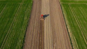 Aerial view of tractor performs seeding on the field video