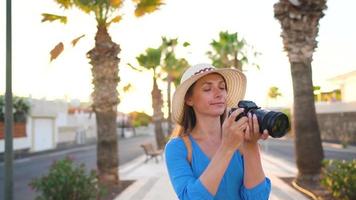 fotograaf toerist vrouw nemen foto's met camera in een mooi tropisch landschap Bij zonsondergang video