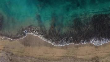 Top view of the desert black beach on the Atlantic Ocean. Coast of the island of Tenerife. Aerial drone footage of sea waves reaching shore video