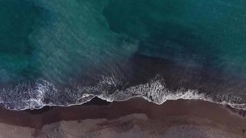 parte superior ver de el Desierto negro playa en el atlántico océano. costa de el isla de tenerife aéreo zumbido imágenes de mar olas alcanzando apuntalar video