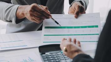 Financial analysts analyze business financial reports on a digital tablet planning investment project during a discussion at a meeting of corporate showing the results of their successful teamwork. video