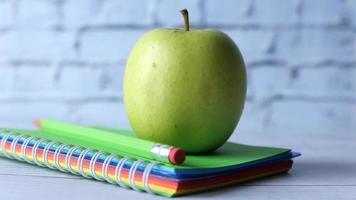 pilha do caderno, maçã e lápis em mesa video
