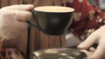 mujer en médico guantes Bebiendo café a café video