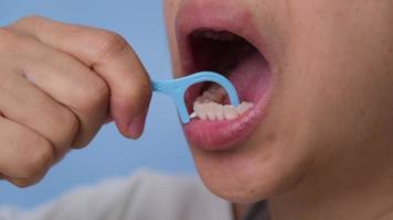 de cerca de sonriente asiático mujer y limpieza para Perfecto sonrisa. sano blanco dientes por limpieza con hilo dental, oral salud y dental cuidado. video