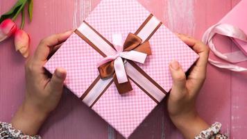 Top view of women hand holding pink color gist box video