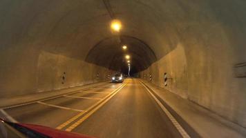 Fahren Auto im ein Tunnel. Auto Fahren durch ein lang, lampenbeleuchtet Tunnel im das norwegisch Berge video