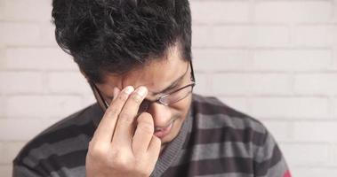 Young man suffering headache, close up video