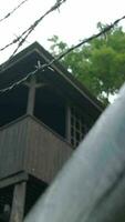 Barbed wire fence surrounds exterior of wooden structure video