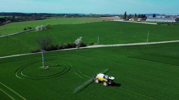 Aerial view of combine spraying green field video