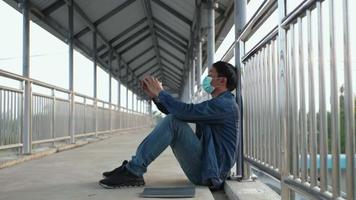estresado asiático hombre sentado en un puente video