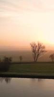 antenn se av dimmig morgon- ljus över grön lantlig landskap video