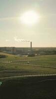 Aerial view of field and smoking tower on horizon video