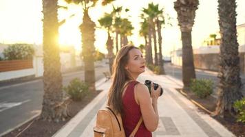 Photographer tourist woman taking photos with camera in a beautiful tropical landscape at sunset video