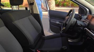 mulher dentro uma azul vestir senta dentro a carro, aperta dela assento cinto e coloca a chave dentro a ignição antes dirigindo video