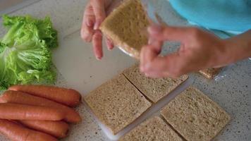 Zeit Ablauf von Kochen Avocado Toast - - Frau schneidet das Avocado und nimmt aus das Fruchtfleisch, Koteletts es und setzt auf brot, Salz- und streuen mit Gewürze. gesund vegan Frühstück video