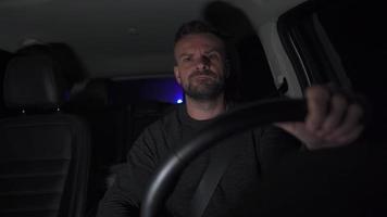 Mens schijven een auto en begint vloeken en verontwaardigd wanneer hij ziet de knippert lichten van de Politie achter hem Bij nacht. visie binnen auto video