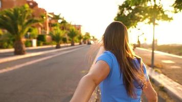 seguir yo - contento joven mujer tracción tipo mano - mano en mano corriendo en un brillante soleado día - concepto de despreocupado moderno vida. lento movimiento video