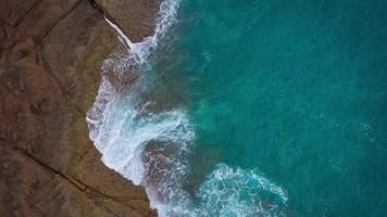 topp se av de öken- strand på de atlanten hav. kust av de ö av teneriffa. antenn Drönare antal fot av hav vågor nå Strand video