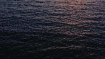 Aerial view of surface of the Atlantic Ocean with reflection of sunlight at sunset video