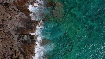 oben Aussicht von ein verlassen Küste. felsig Ufer von das Insel von Teneriffa, Kanarienvogel Inseln, Spanien. Antenne Drohne Aufnahmen von Ozean Wellen erreichen Ufer video