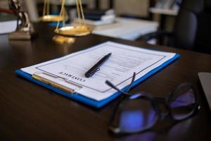 Lawyer holding contract documents in hand and preparing to sign a consulting contract for a team of business people who need legal advice to run their business in accordance with the law photo