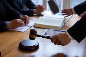 team of lawyers having legal discussion holding judges mallet in their hands to knock on the wooden keyboard. legal counsel for justice in judicial proceedings for purity and fairness of judges. photo