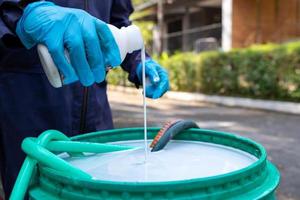 Pest exterminator employees are using pesticide sprayer at client's home and searching for as many nests as possible. An employee from pest control company is spraying chemicals to kill the insects. photo