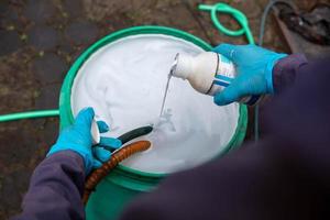 Pest exterminator employees are using pesticide sprayer at client's home and searching for as many nests as possible. An employee from pest control company is spraying chemicals to kill the insects. photo