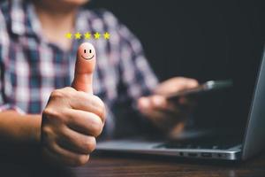 Customer service and Satisfaction concept, Business person are touching the virtual screen on happy Smiley face icon to give satisfaction in service. rating very impressed. customer service feedback. photo