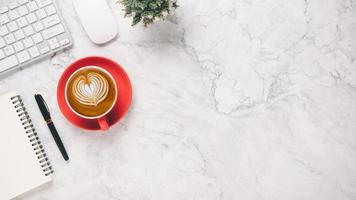 blanco oficina escritorio lugar de trabajo con teclado, ratón, computadora portátil, bolígrafo y taza de café, parte superior ver plano laico con Copiar espacio. foto